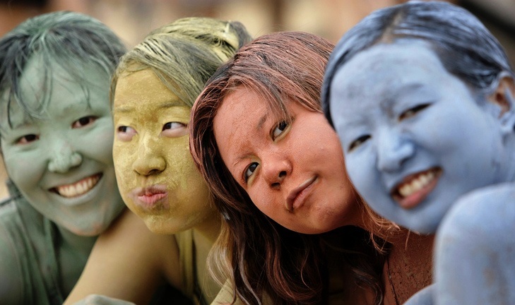 Asian tourists make up with color mud during the Boryeong Mud Festival on Daecheon Beach in Boryeong, south of Seoul, South Korea, Saturday, July 11, 2009. The 12th annual mud festival features mud wrestling, mud sliding and a mud king contest. (AP Photo/ Lee Jin-man)