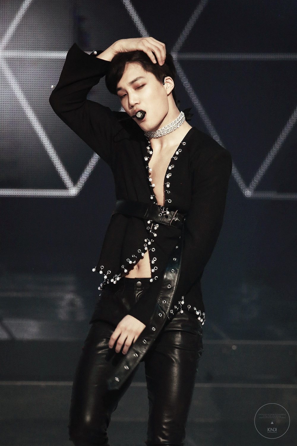 Kai seductively reveals his toned chest as he dances in his embellished suit and diamond choker.