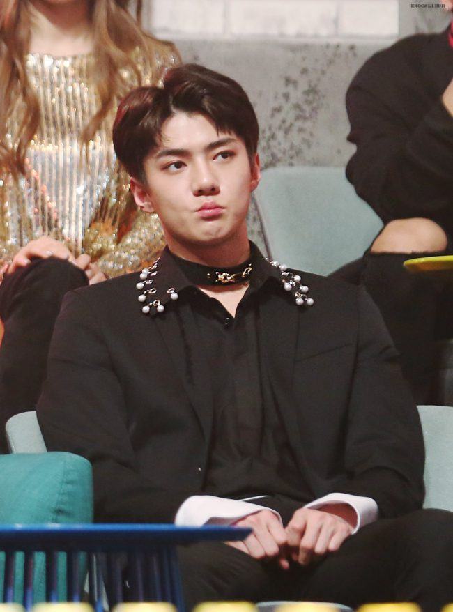 Sehun from EXO can be seen wearing a wide black choker to complete his dark outfit. 