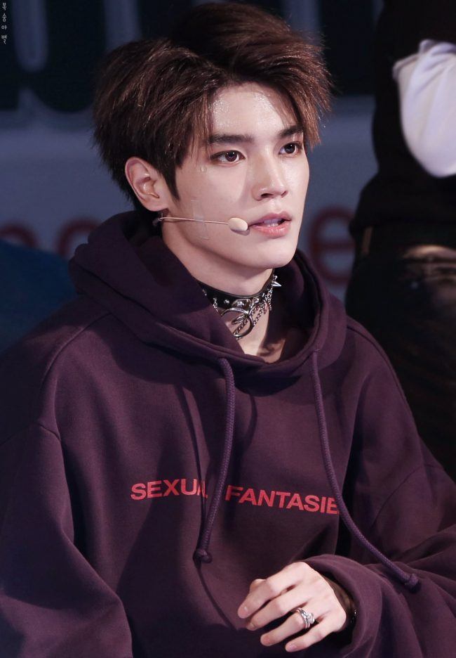 Taeyong from NCT wears an elaborate choker with a wine colored hoodie. 